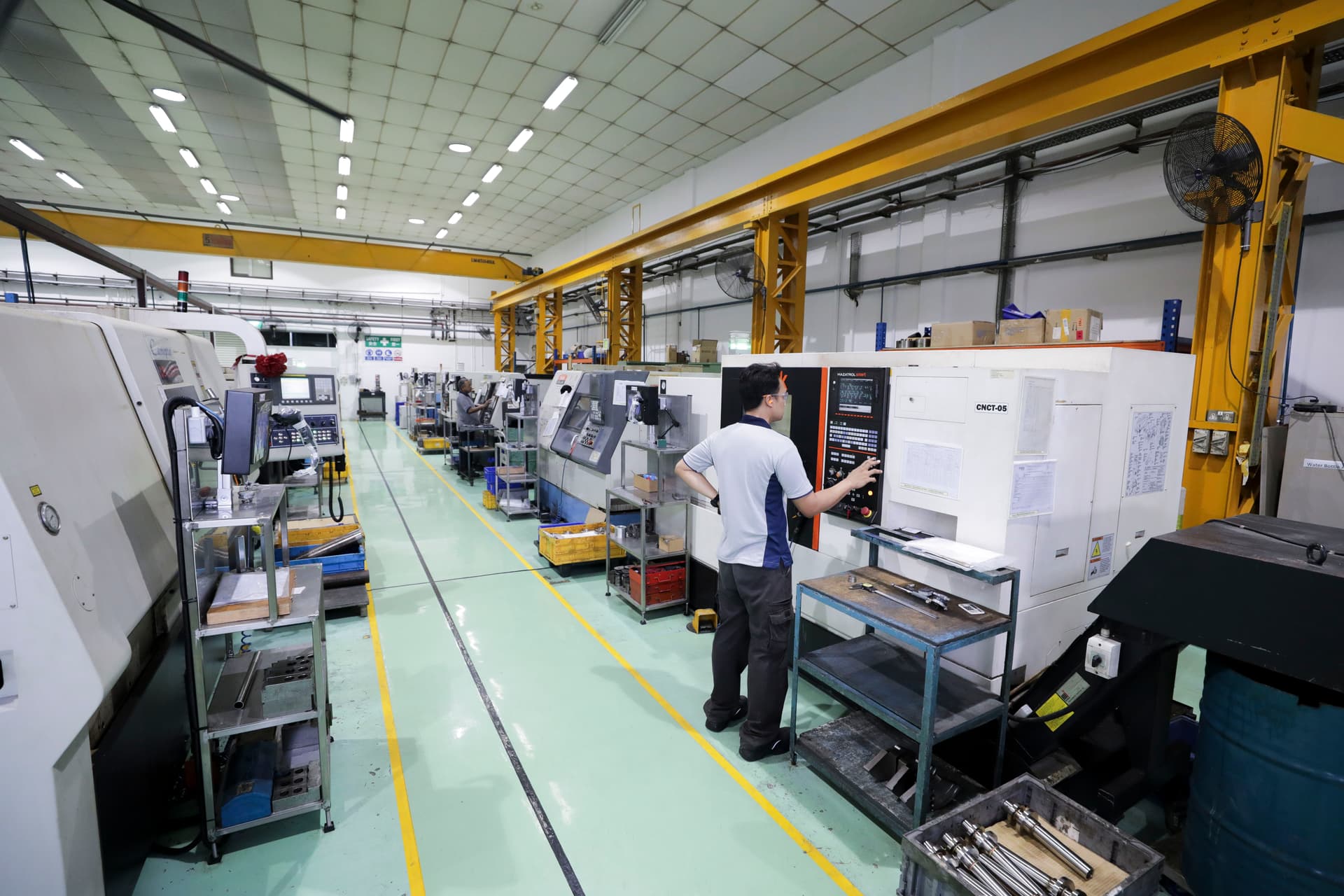 View of factory floor showcasing CNC machines and machinists at work