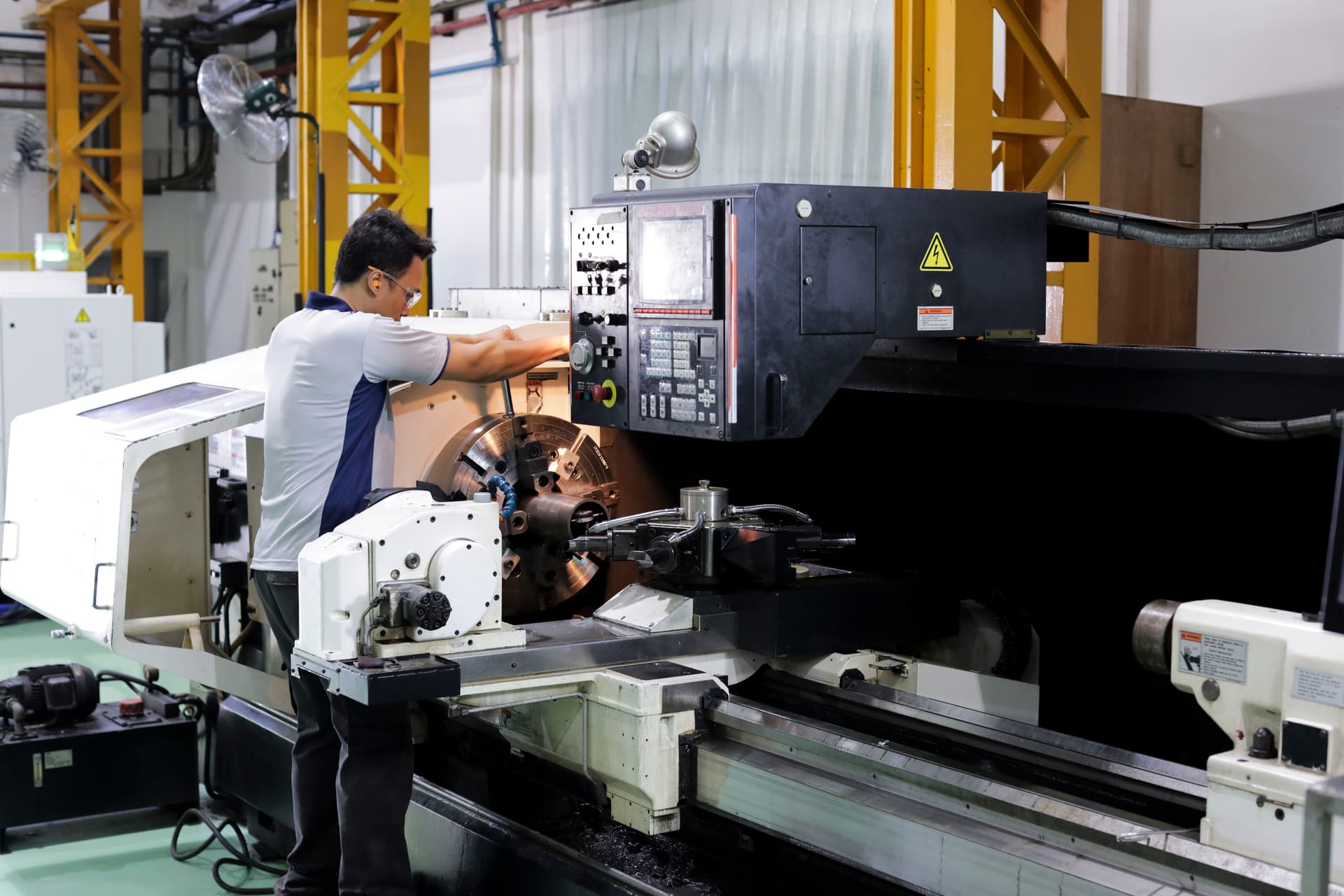 Machinist operating 5-axis CNC machining center at Shine Precision Singapore facility