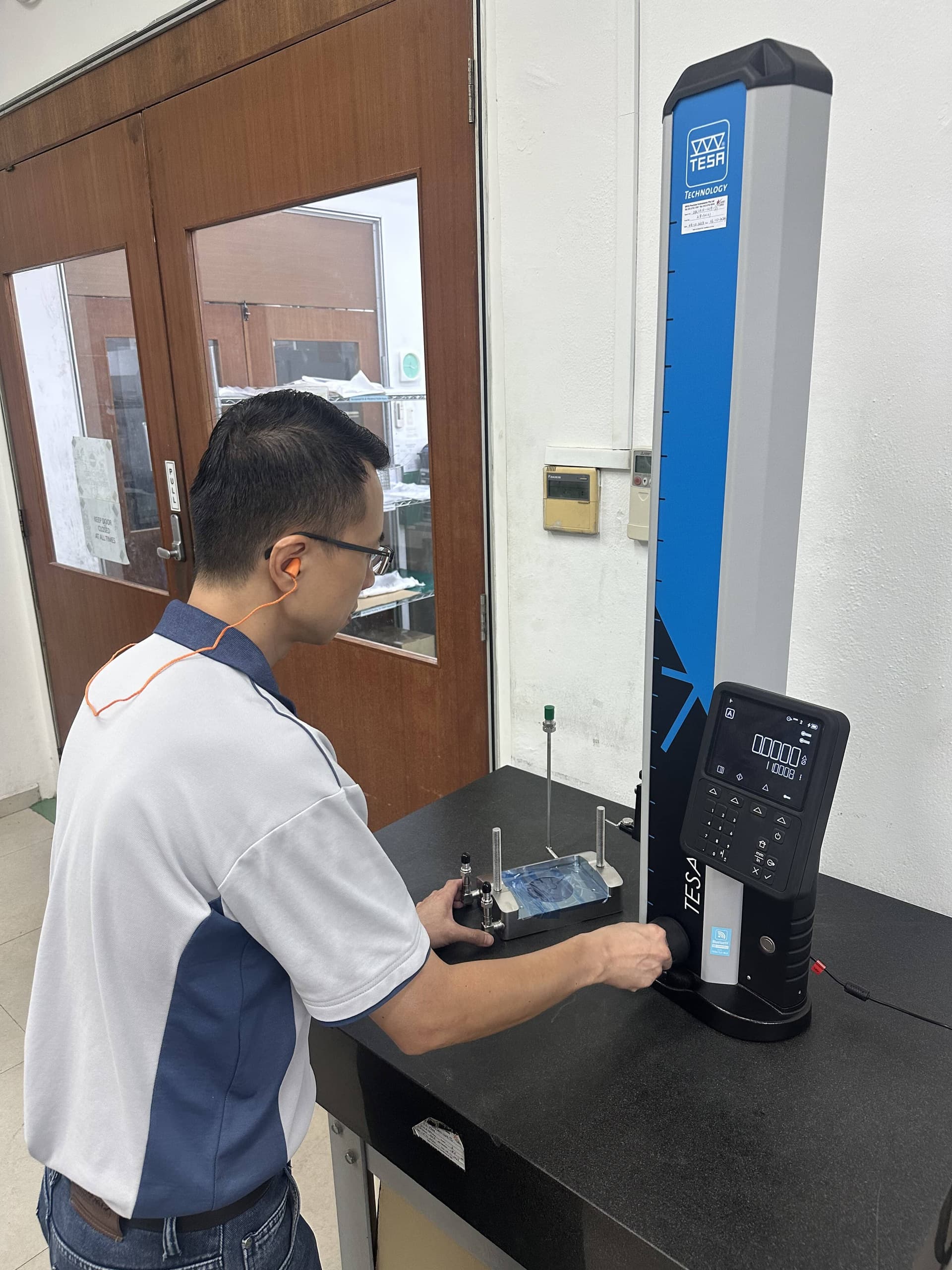 Quality control engineer performing CMM coordinate metrology on tight-tolerance machined component