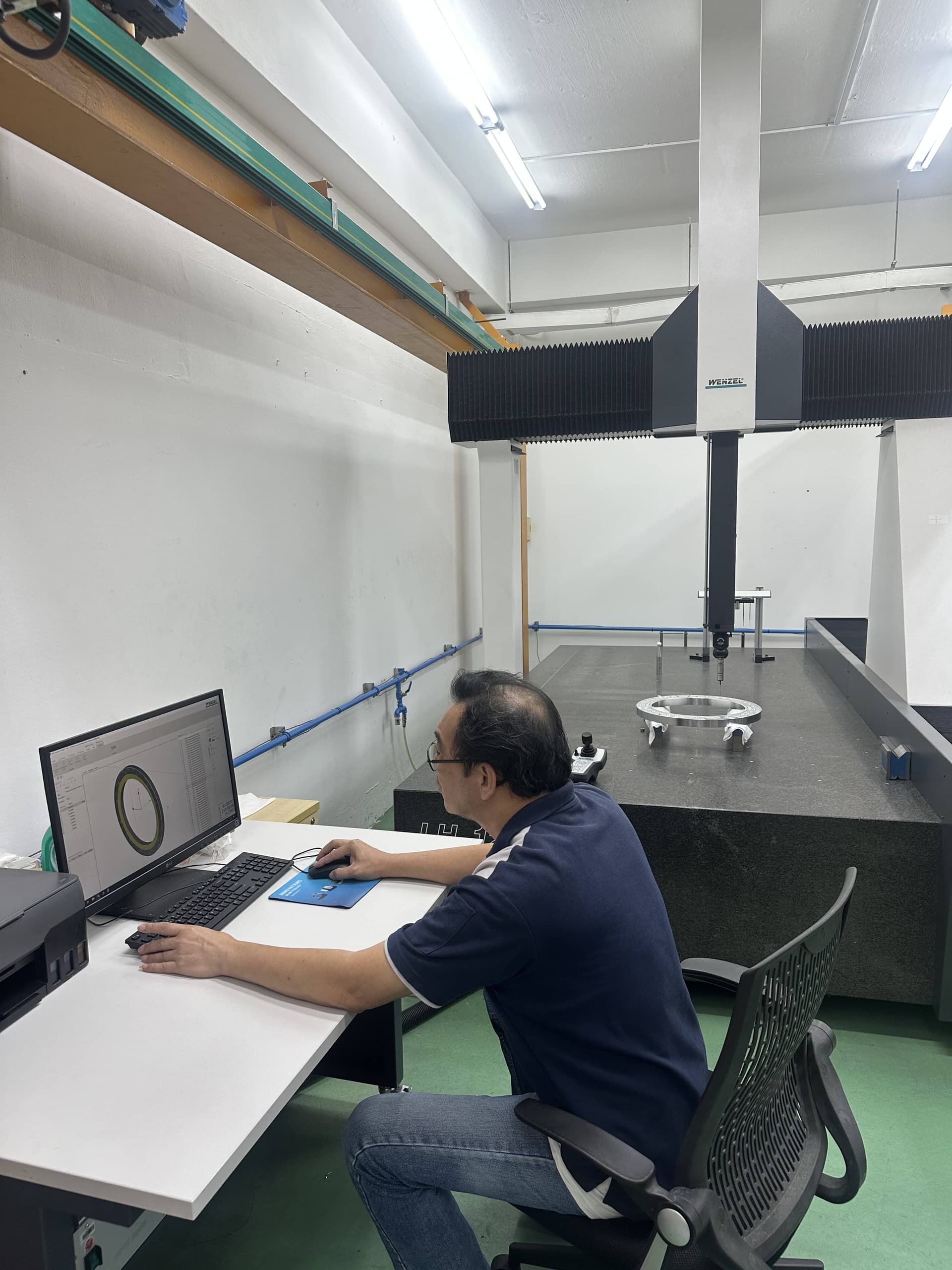 Metrology technician using high-magnification optical vision system for precision feature inspection